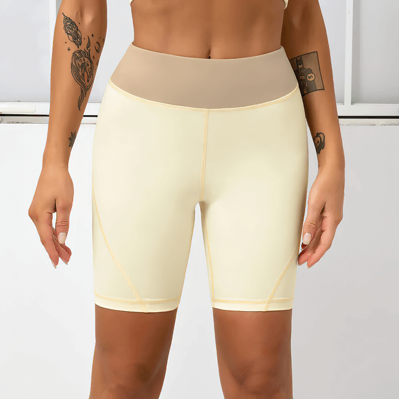 Woman wearing high waist two-color sports shorts, highlighting comfort and performance with spandex material for workouts.